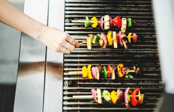 A GrillSteam technician steam-cleaning a grill